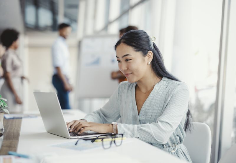 Smiling woman looking at laptop screen
