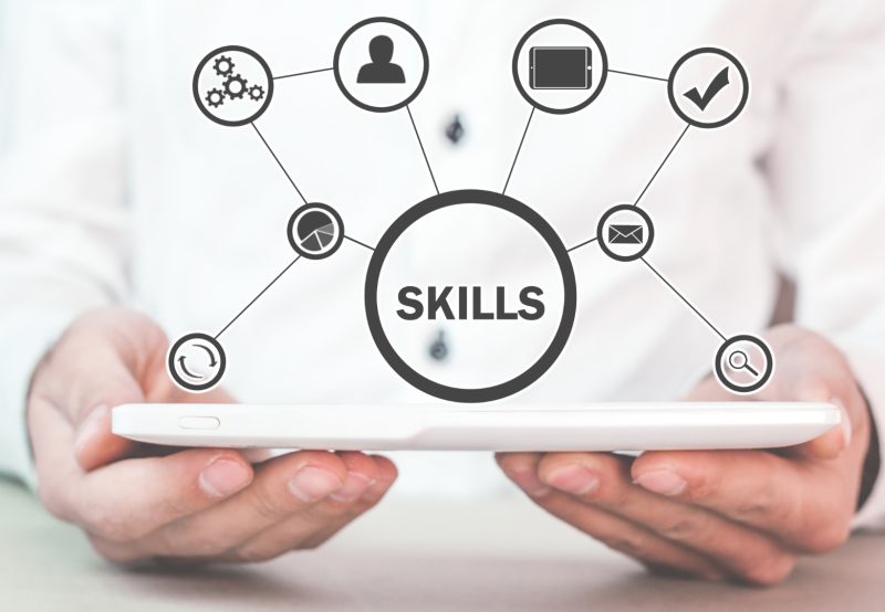 Man holding a tablet with a diagram of skills coming out of it