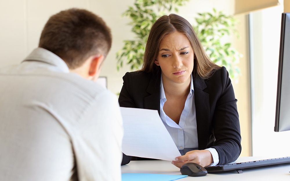 Woman looking suspiciously at a resume wondering if they contain any white lies. See why they matter.