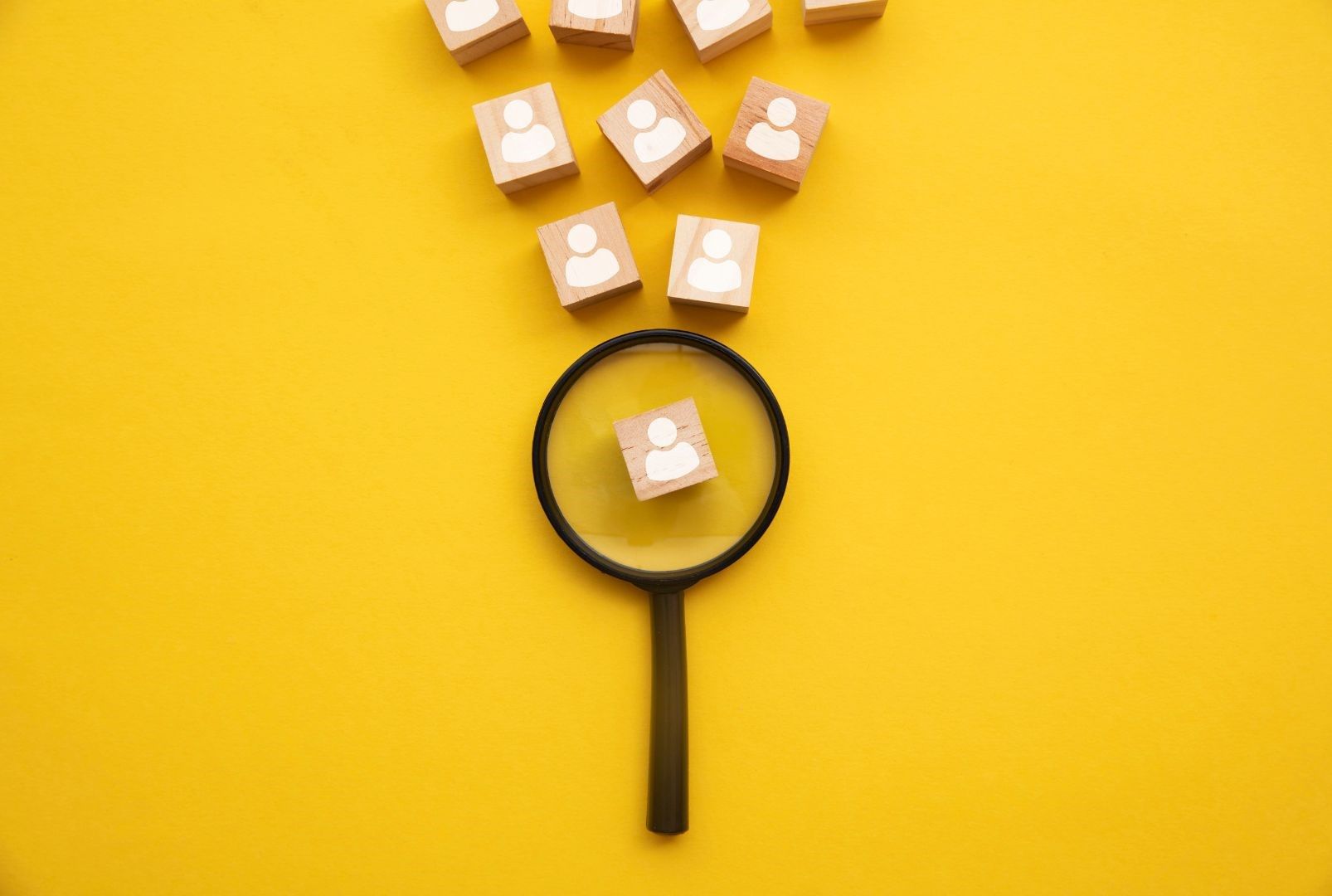 Yellow background with a magnifying glass highlighting a persona.  