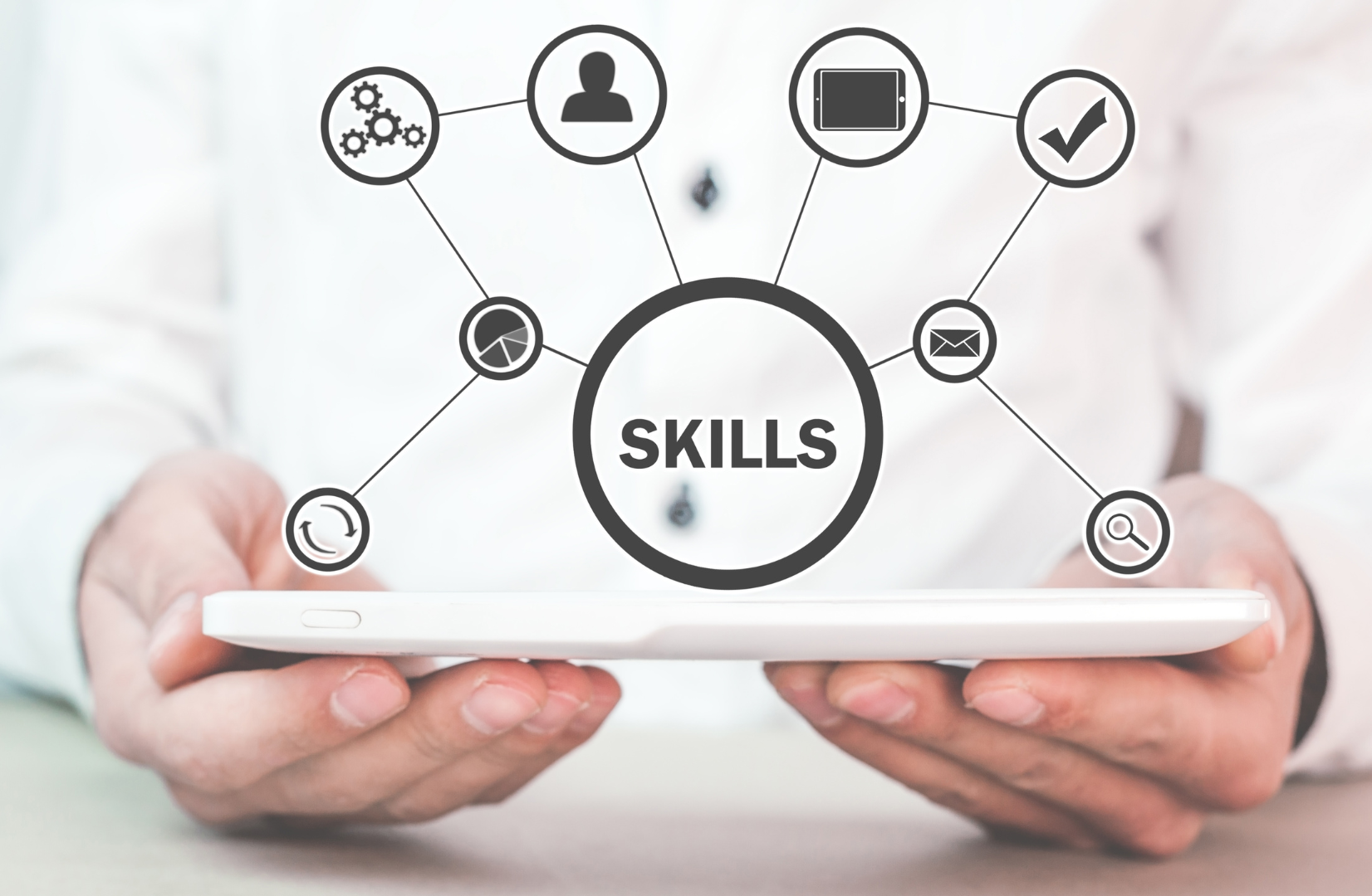 Man holding a tablet with a diagram of skills coming out of it