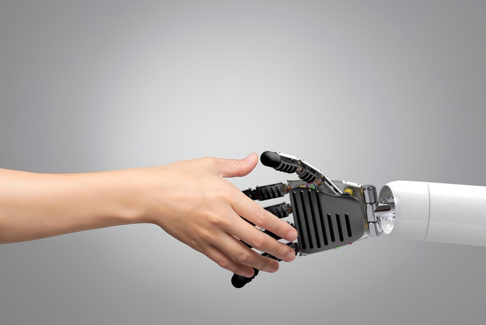 Human hand going to shake a robotic hand.